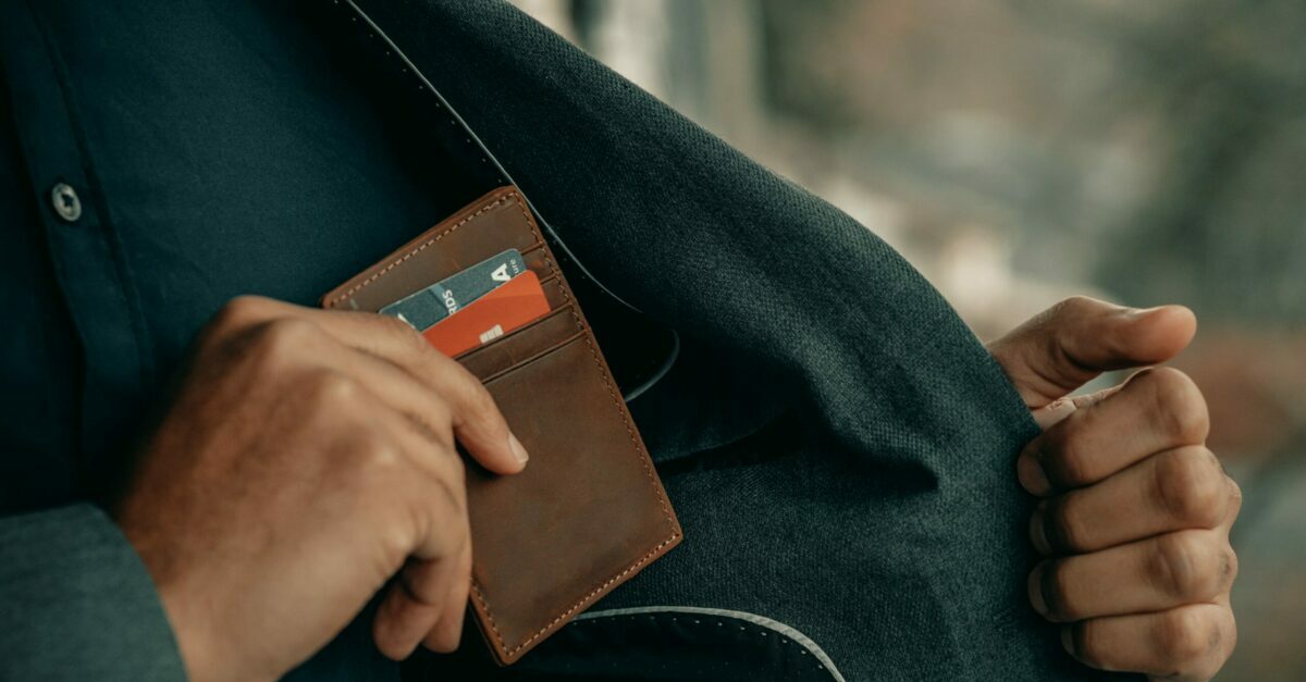 A men keeping his credit card filled wallet in jacket.
