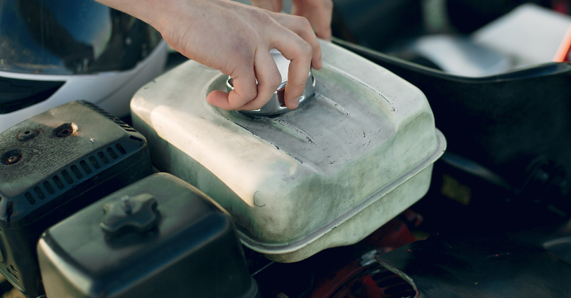 A pair of hands opening a coolant reservoir.