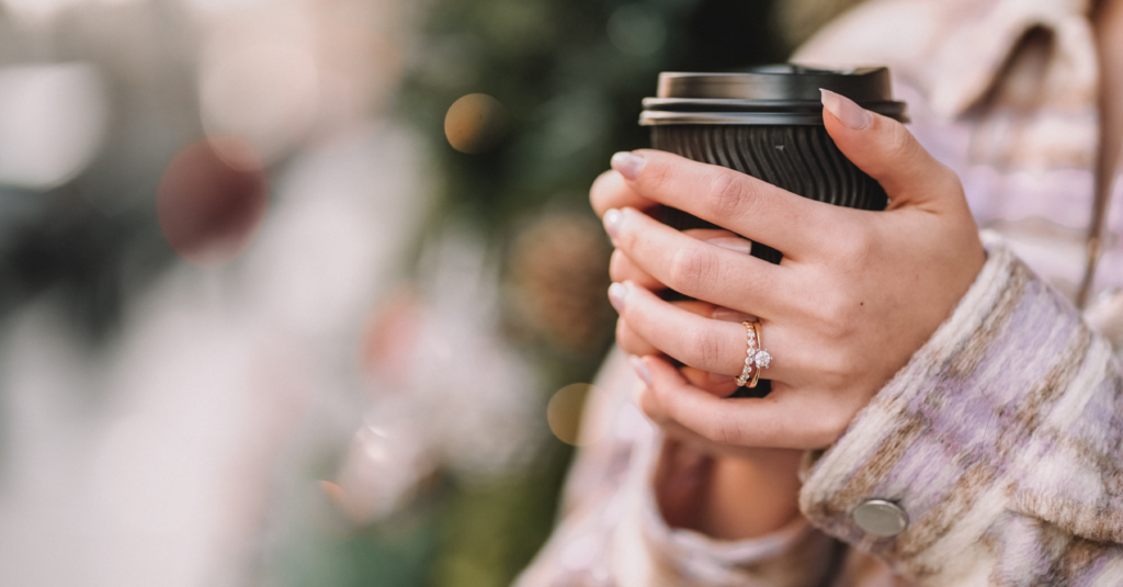 A Women Holding A Black Take Away Cup.